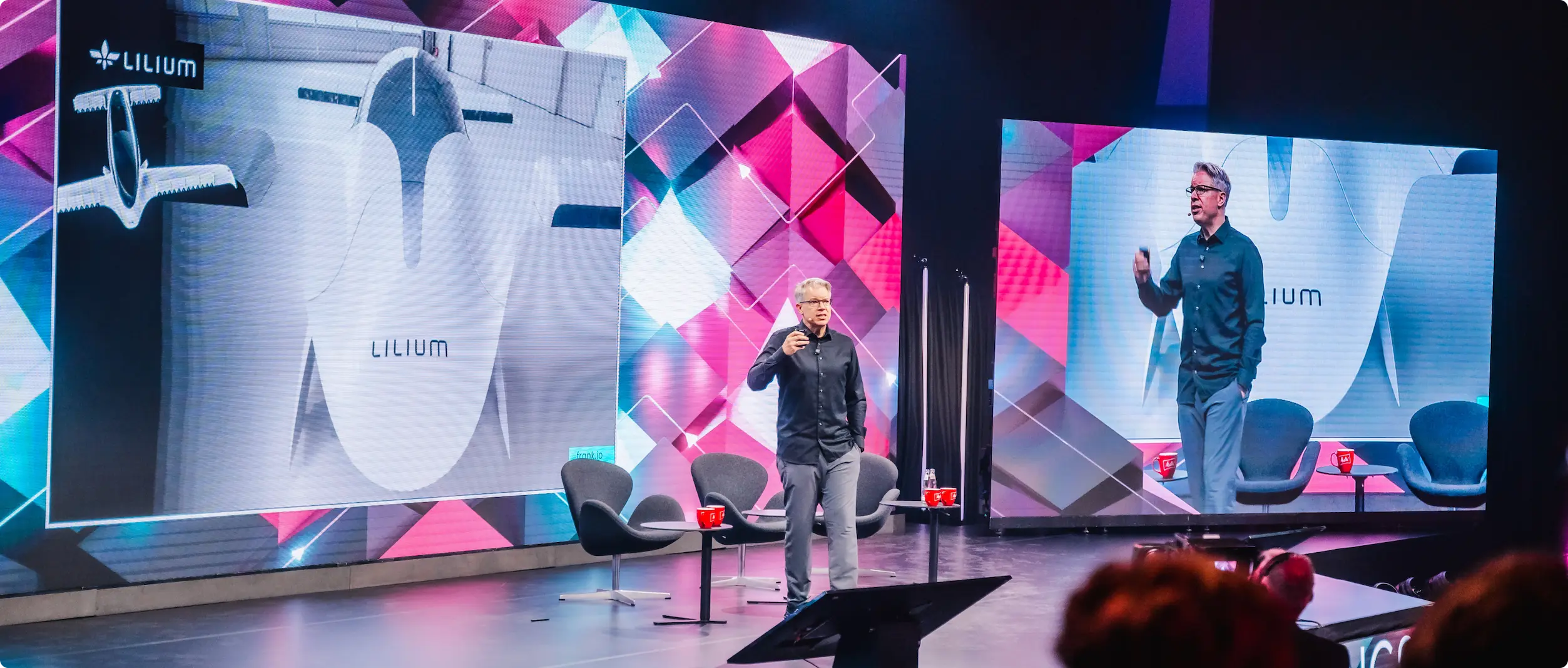 Frank Thelen presenting on stage at Lilium Aviation event, showcasing his venture studio Freigeist's deep-tech investment portfolio with multi-property design system branding.